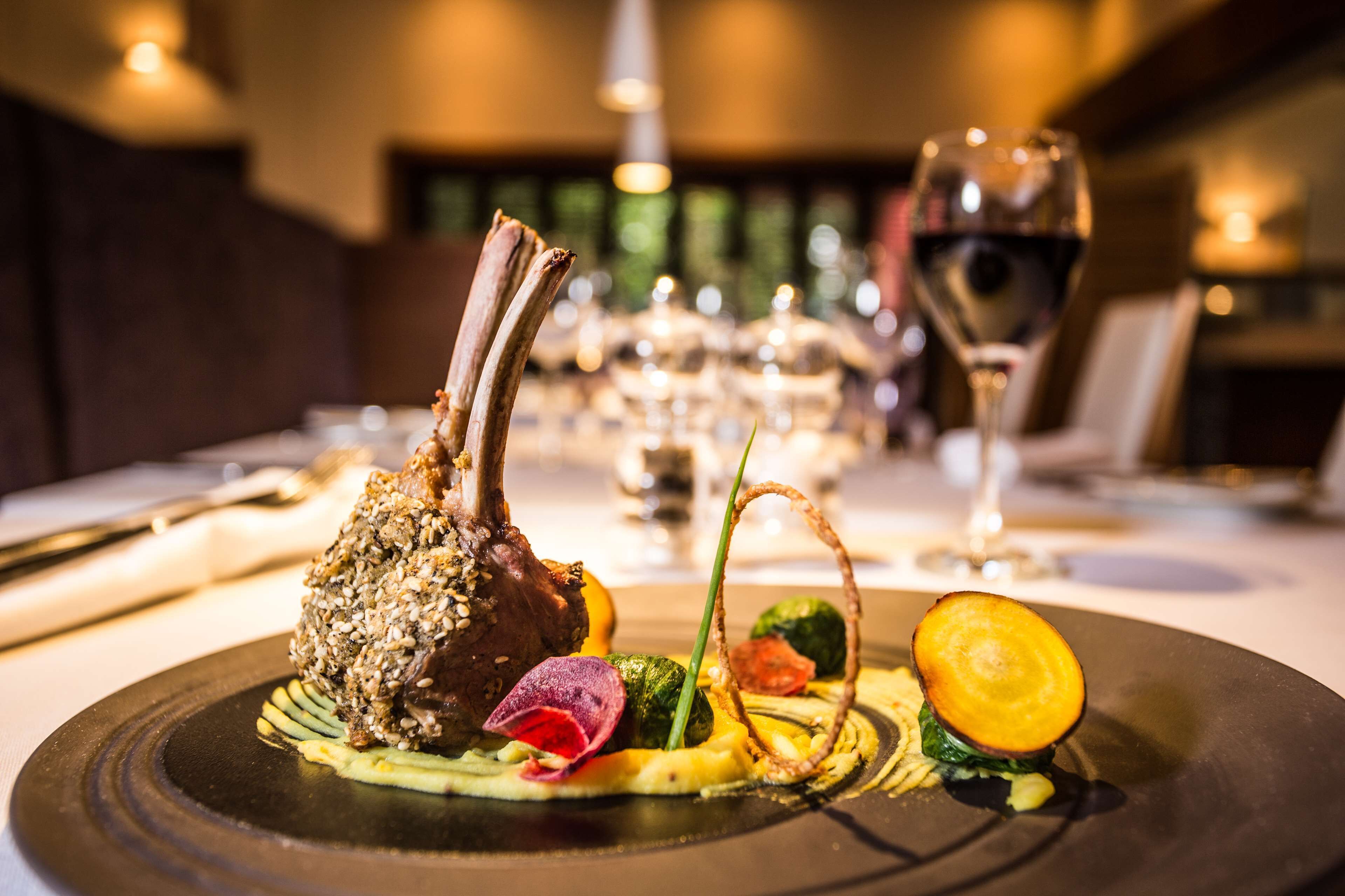 Una mesa de comedor elegantemente dispuesta, con un plato, una copa de vino y un tenedor.