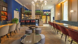 A modern hotel lobby with a bar area, seating arrangements, and a staircase leading to an upper level. - Princes Street Suites (Edinburgh)