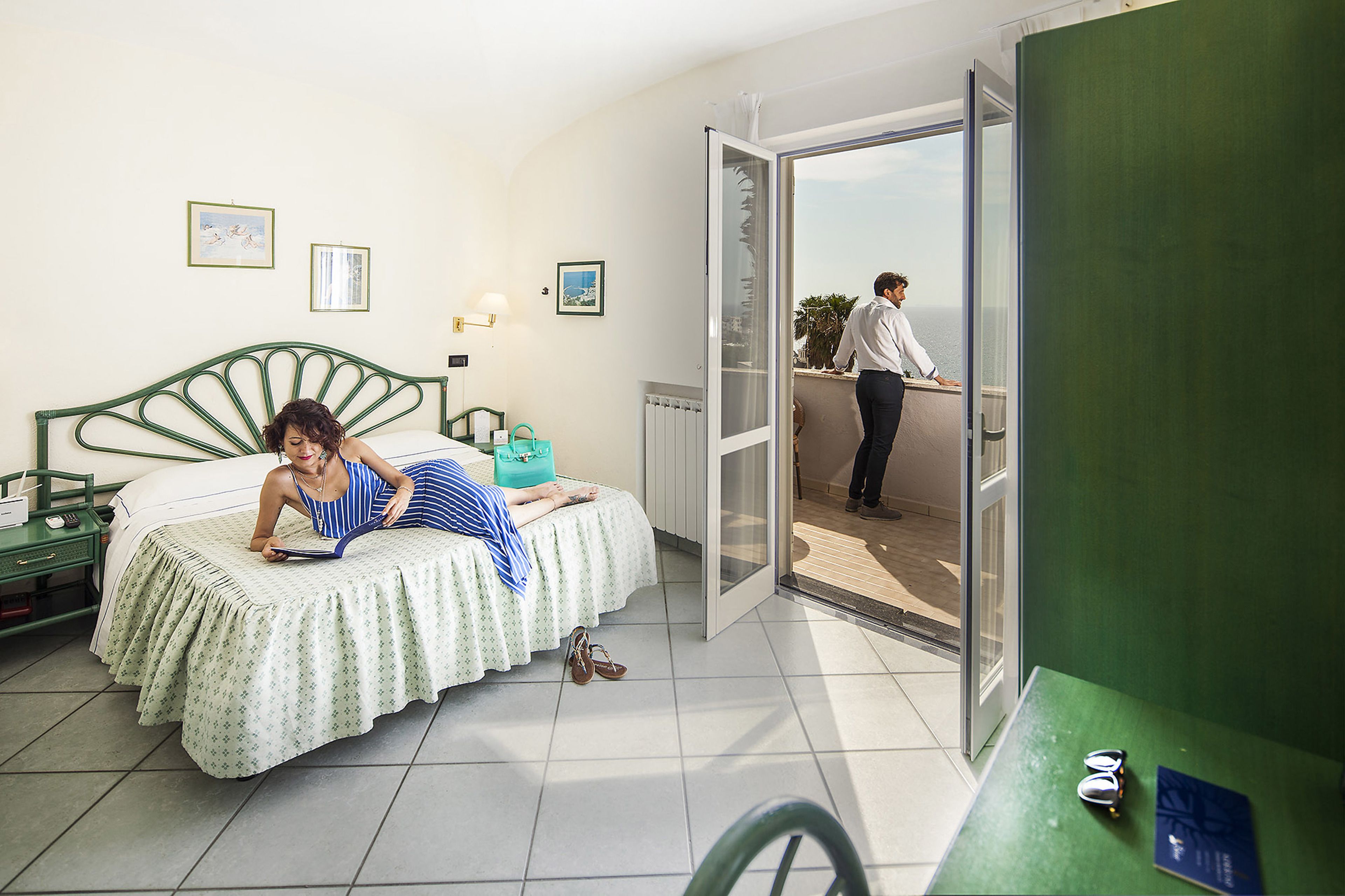 A room with a bed, a window, and a door leading to an outdoor area.