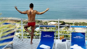 Guests can enjoy stunning ocean views from the balcony, featuring comfortable lounge chairs and refreshing amenities.