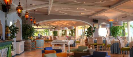 A spacious lobby with a grand piano, comfortable seating, and decorative lanterns.