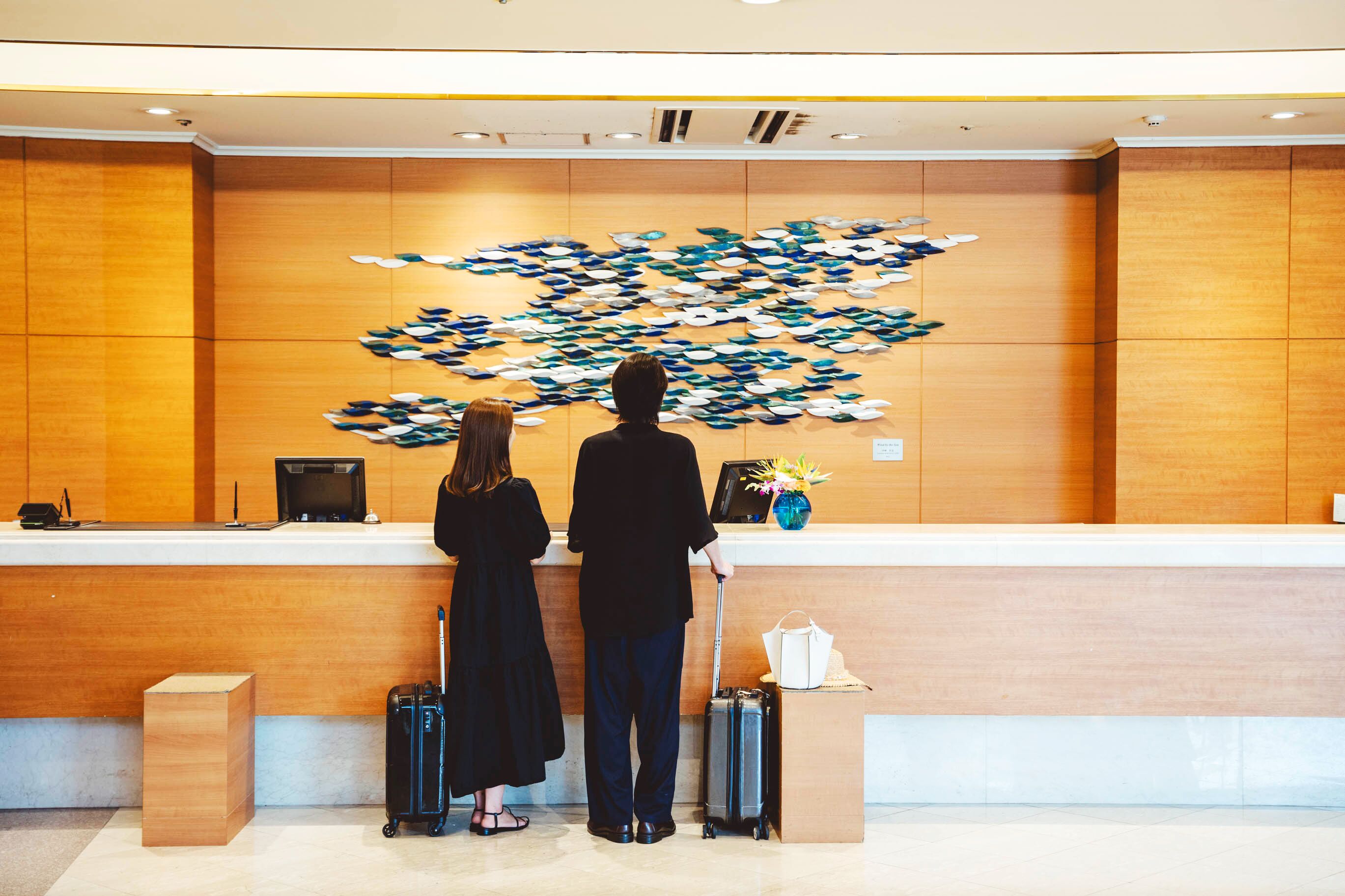 A reception desk with a large, abstract wall art piece above it.