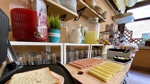 A kitchen counter with sliced meats, bread, and a cutting board.
