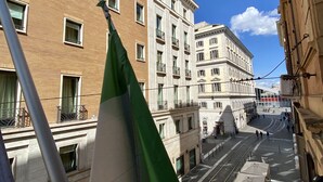 A street view with buildings, a flag, and a tram line.