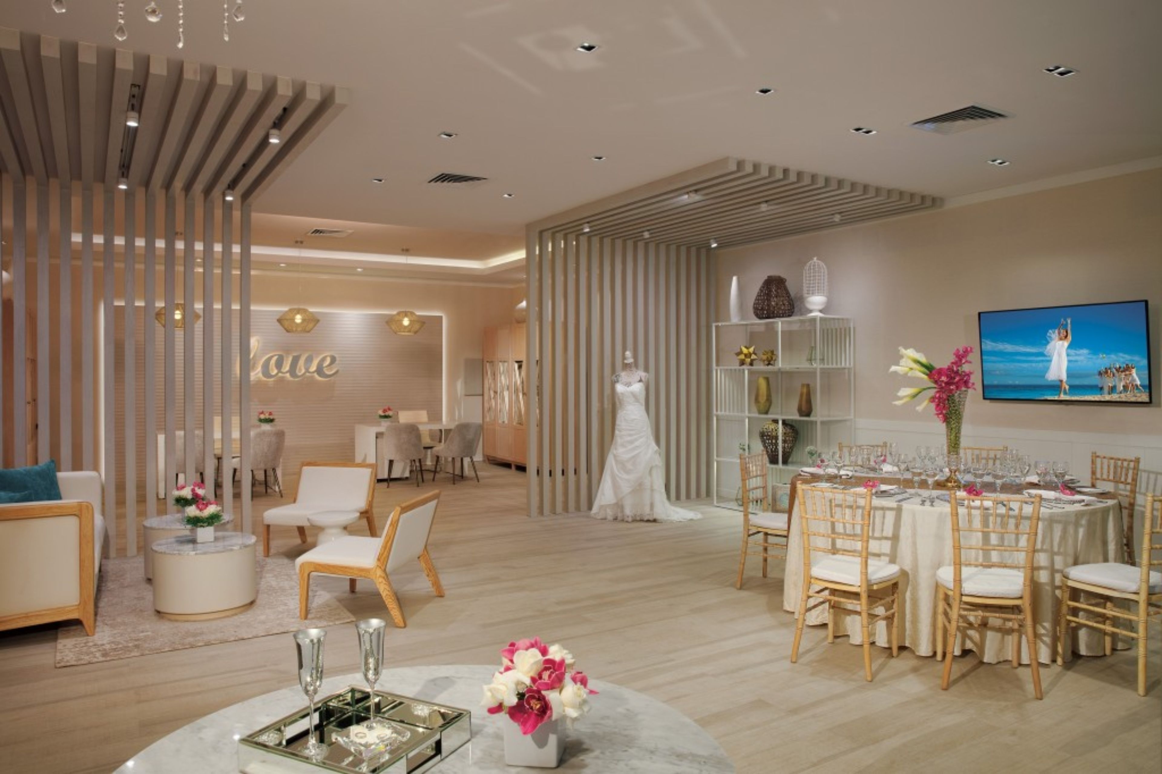 Un salón de bodas con área de recepción, exhibición nupcial y montaje para el banquete.