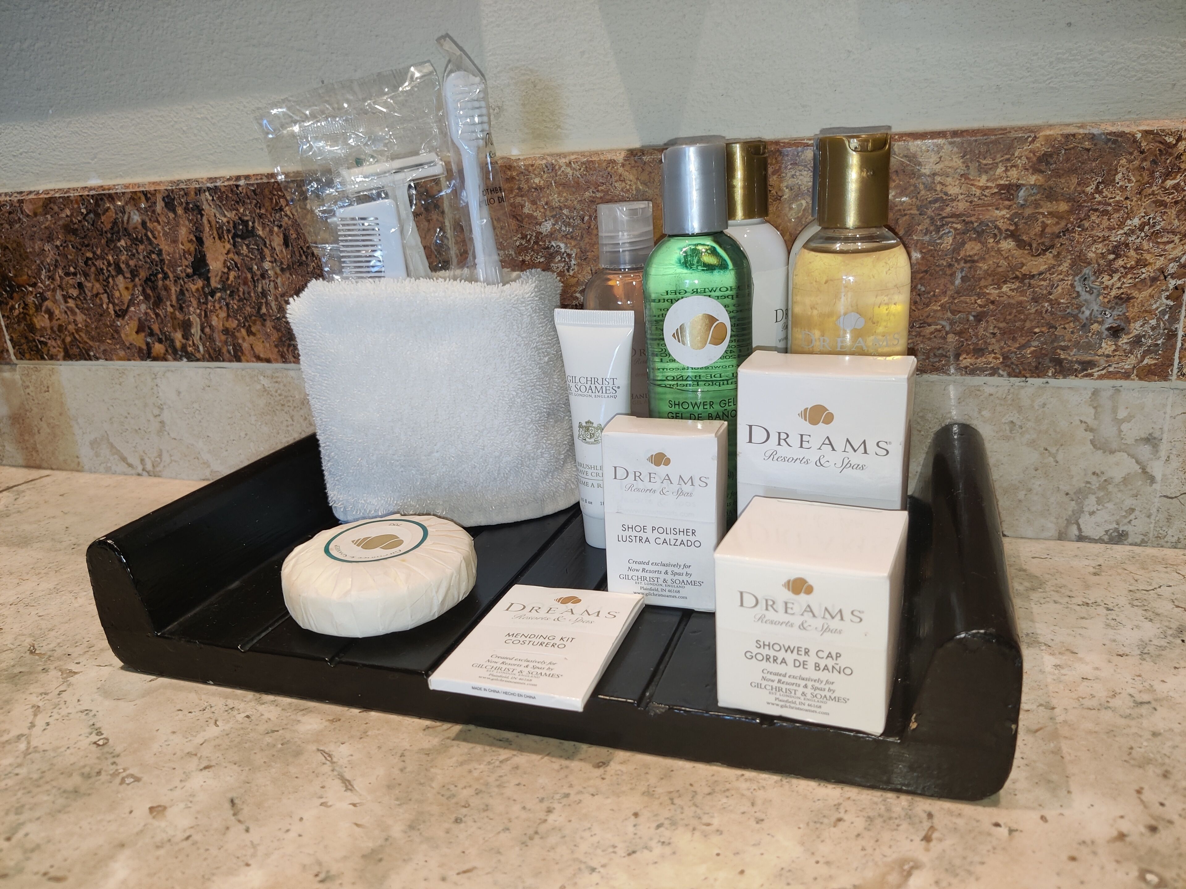 A tray with toiletries including a toothbrush, toothpaste, and a shower gel bottle.