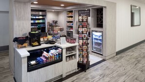 Een automaat met koude drankjes, snacks, en een overzicht van koffie- en thee-opties.