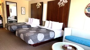 A hotel room with two beds, a sofa, a coffee table, and a smoking area sign. - Oxford Inn Ozark (Ozark)