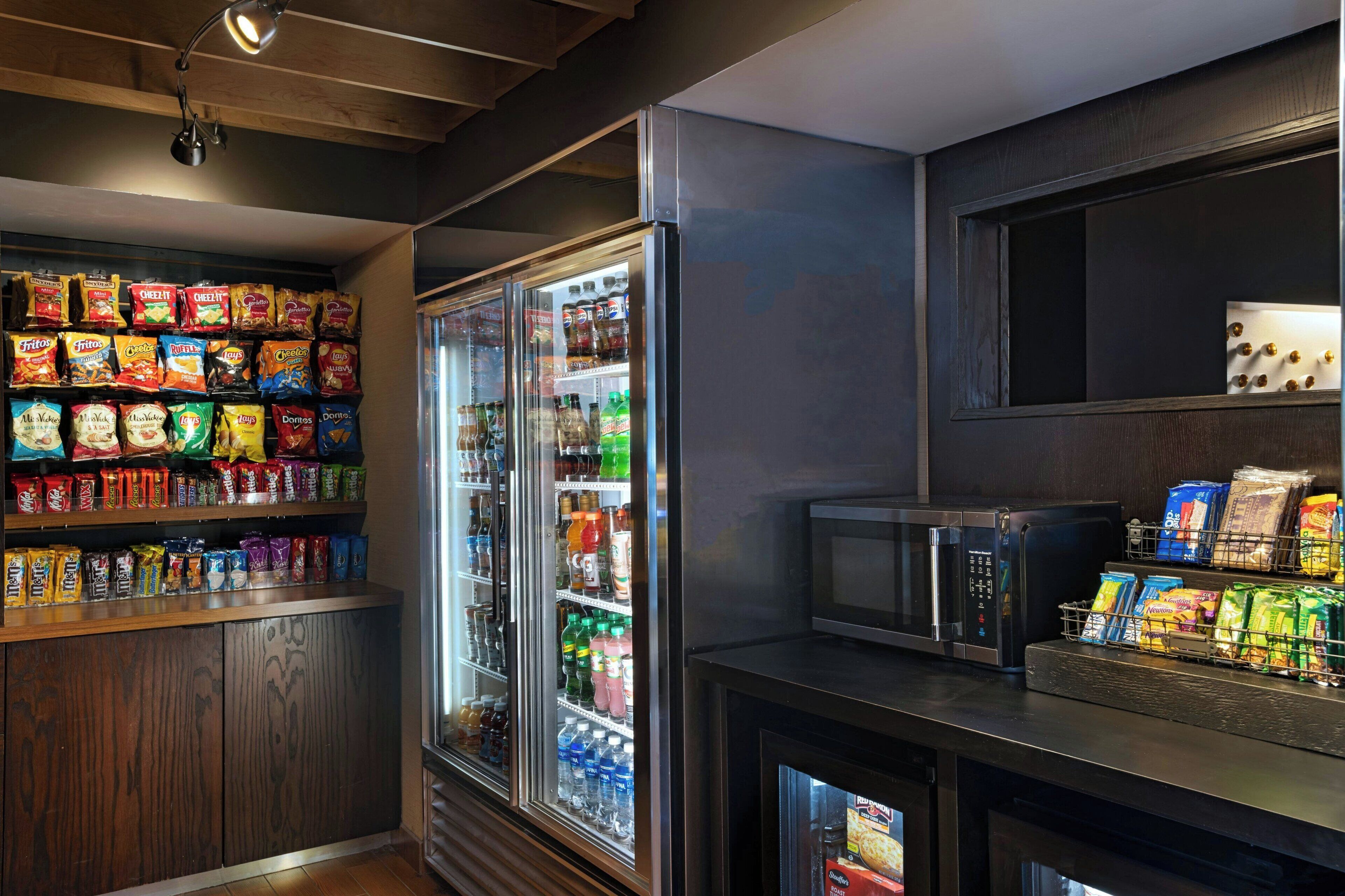 Een kitchenette met een magnetron, koelkast en ruimte voor snacks.