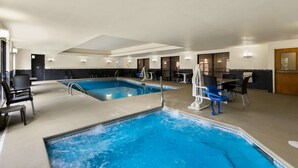 Zona de piscina de hotel con dos piscinas, sillas de descanso y mesas.