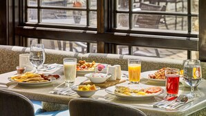 A breakfast table set with various dishes, drinks, and utensils.