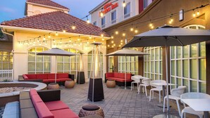 Ein Patio im Freien mit Sitzgelegenheiten, Lichterketten und einem Gebäude, dessen Schild "Garden Inn" zeigt.