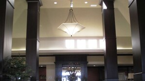 A spacious lobby with a central table, large windows, and a hanging light fixture. - Hilton Garden Inn Clovis (Clovis)