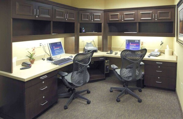 Un espacio de oficina profesional con dos escritorios, computadoras, sillas y archivadores.