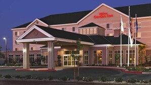 A large, multi-story hotel with a prominent entrance and a covered area. - Hilton Garden Inn Clovis (Clovis)