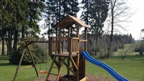 Estructura de madera con un tobogán en un área cubierta de césped.