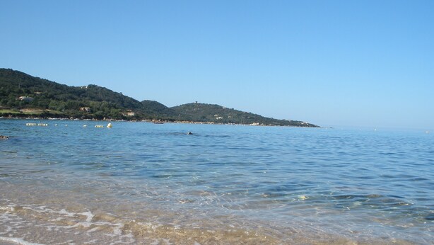 A beach with clear water, a sandy shore, and hills in the background. - Hôtel Céline (Coti-Chiavari)