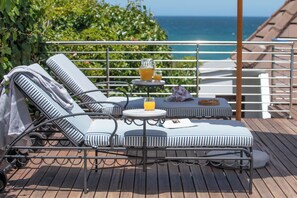 Una piscina al aire libre, sombrillas, sillones reclinables de piscina