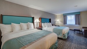 A hotel room with two beds, a desk, a chair, and a window with curtains. - Best Western Hampshire Inn (Seabrook)
