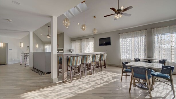 A spacious room with a dining area, a bar, and a ceiling fan. - Best Western Hampshire Inn (Seabrook)