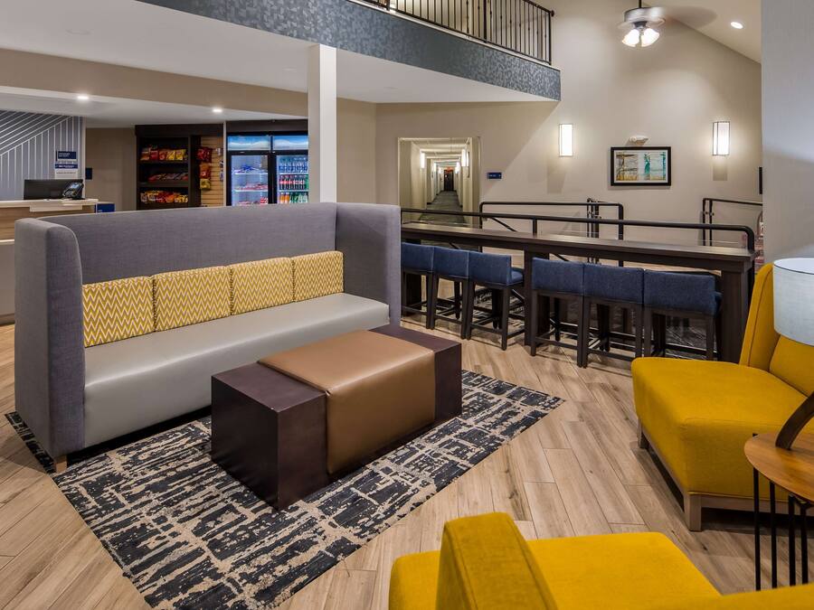 A hotel lobby with a reception desk, seating area, and a dining area.