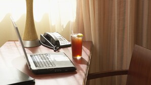A hotel room with a desk, a laptop, a telephone, and a glass of iced tea. - Country Inn & Suites by Radisson, Knoxville at Cedar Bluff, TN (Knoxville)