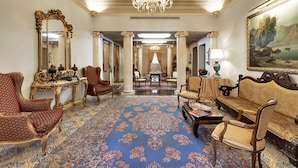 A grand room with ornate furniture, a large chandelier, and a detailed carpet. - Relais Antica Badia - San Maurizio 1619 (Ragusa)