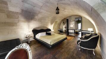 A bedroom with a large bed, a chair, and a mirror.