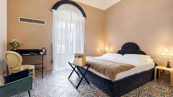 Habitación de hotel con cama, escritorio, silla y piso estampado.