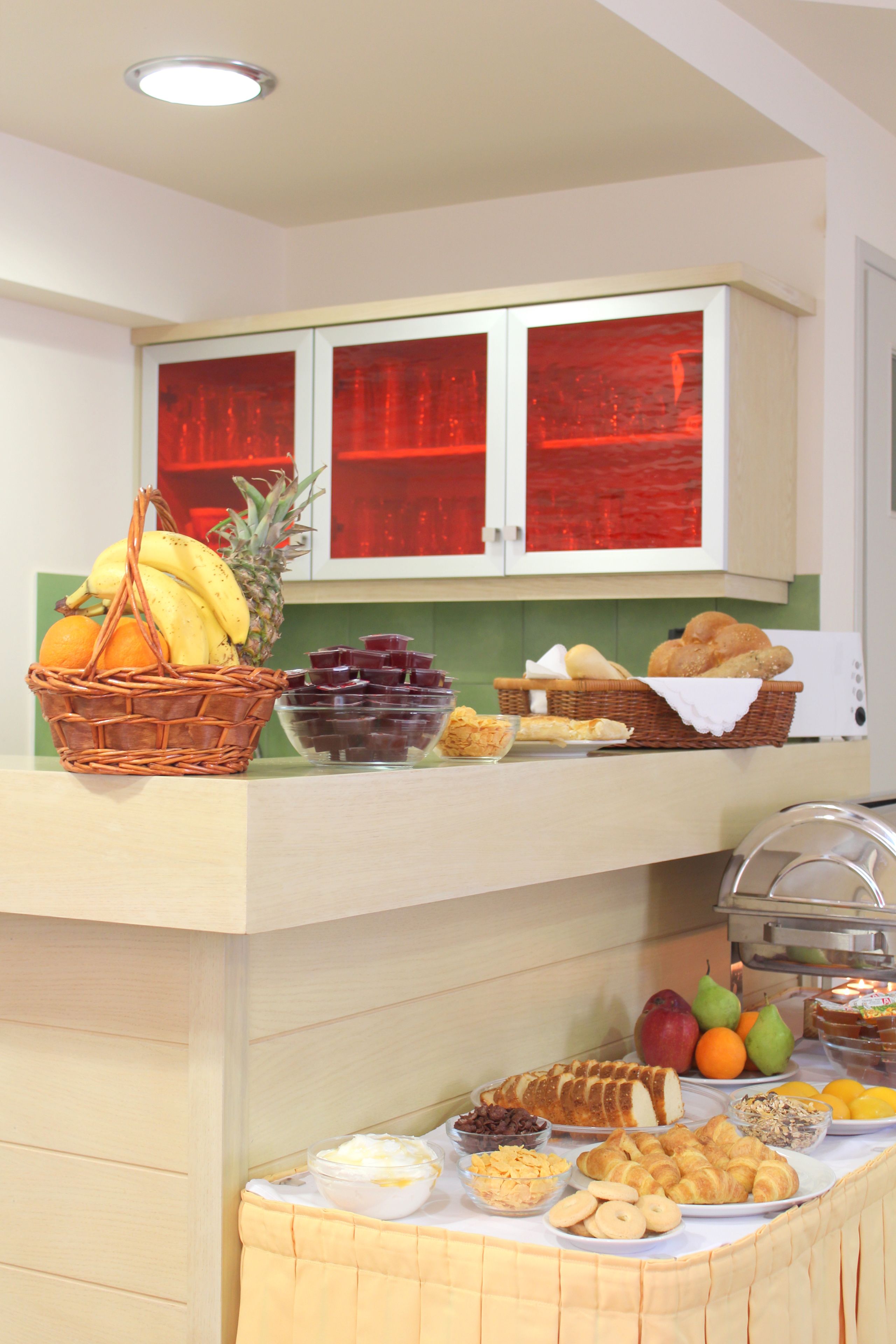 Un buffet proposant une variété de plats et un panier de fruits.