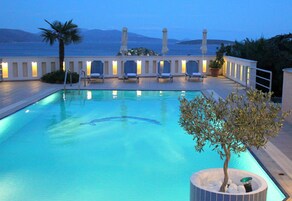 Una piscina al aire libre, sombrillas, tumbonas