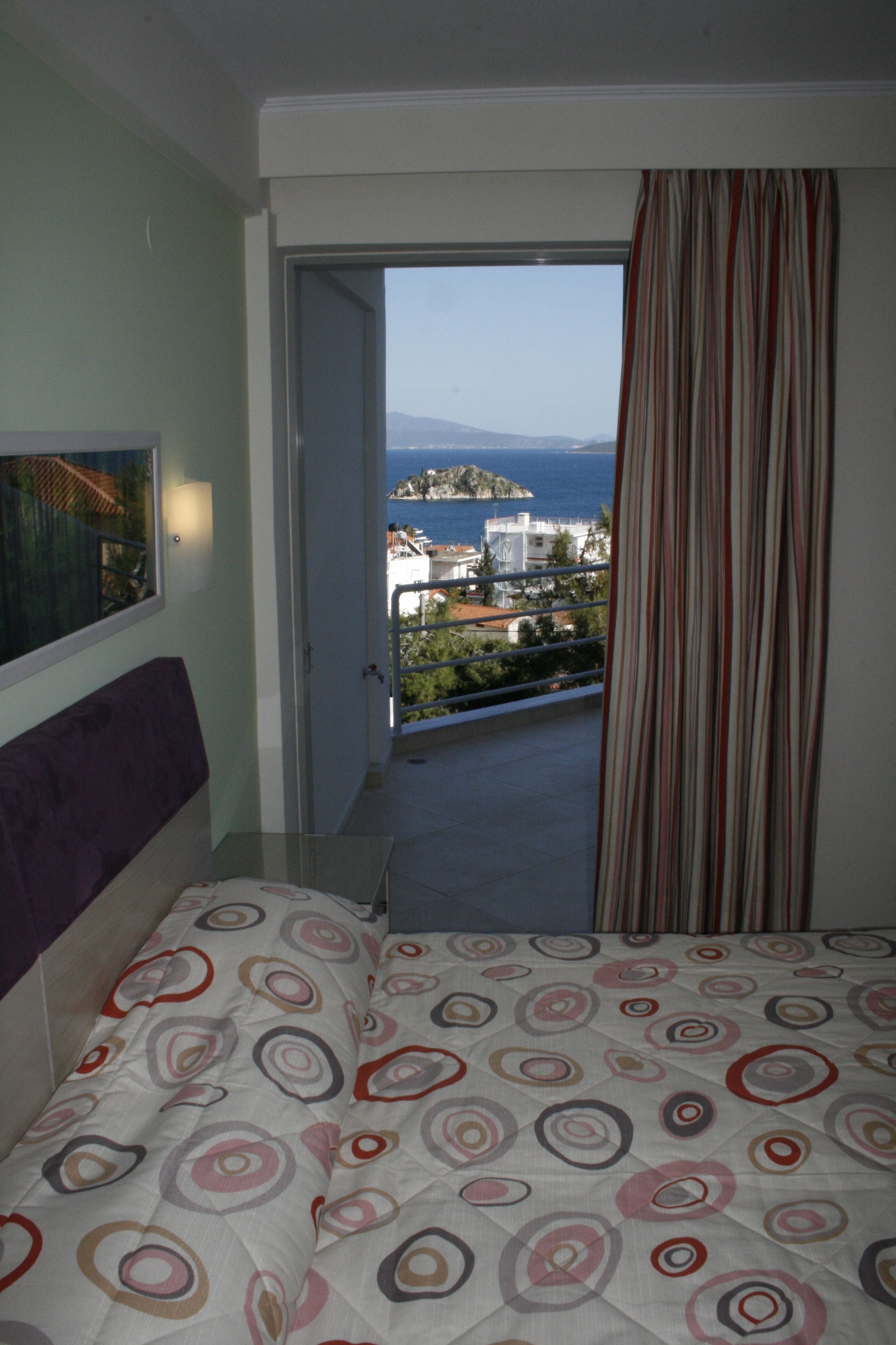 Una habitación de hotel con una cama, vistas al mar y un balcón.