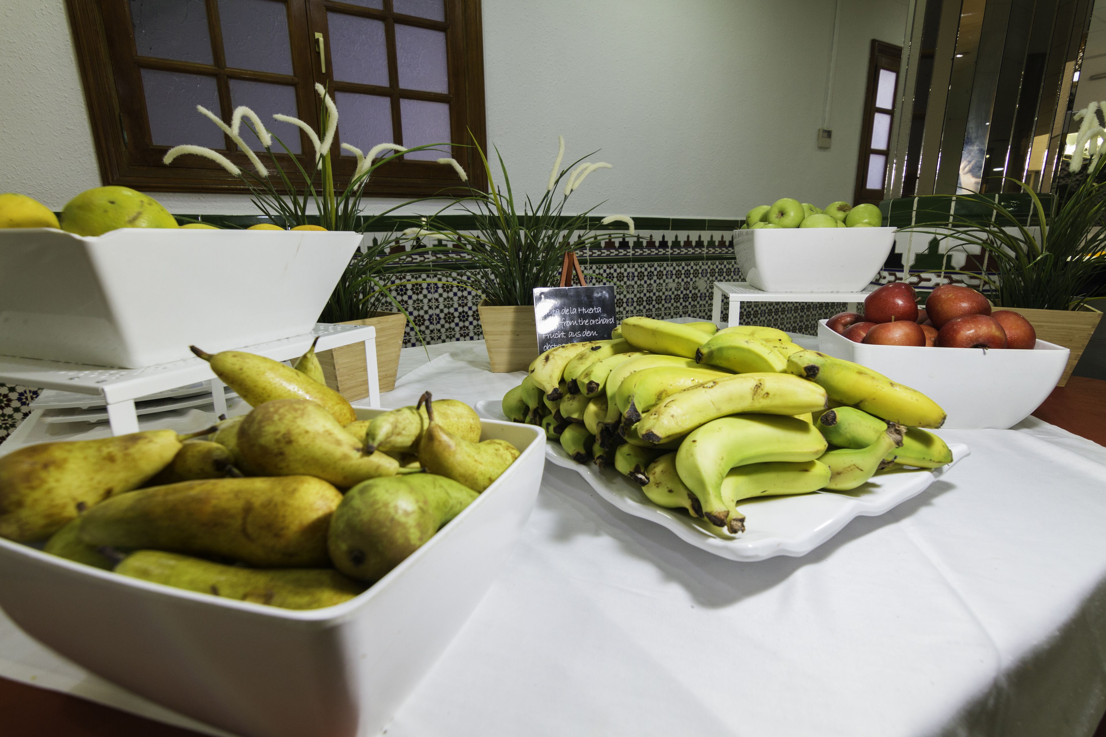 A table with various fruits including bananas, apples, and pears.