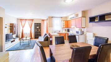 A modern apartment with a dining area, kitchen, and living room.