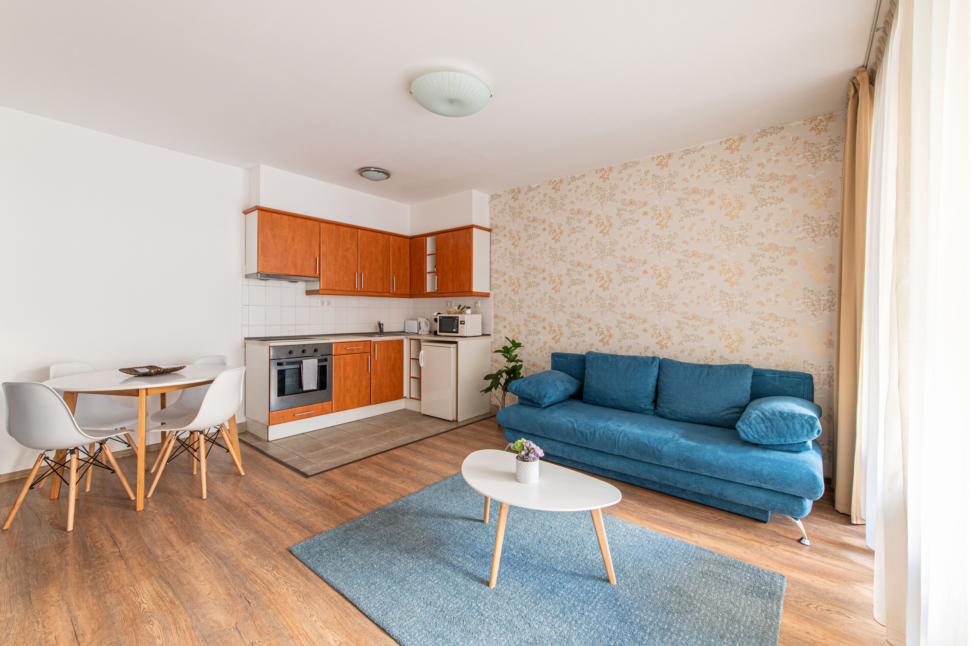 A modern apartment with a kitchen, dining area, and living room.