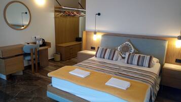 A bedroom with a bed, bedside tables, a desk, a mirror, and a wardrobe.
