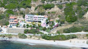 A coastal hotel with multiple buildings, a beach, and clear waters. - Horizon Beach Hotel (Agios Vasileios)