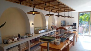 A buffet setup with various food items and serving utensils. - Horizon Beach Hotel (Agios Vasileios)