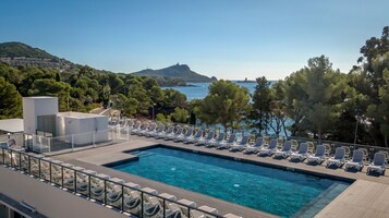 Una piscina al aire libre, sillones reclinables de piscina