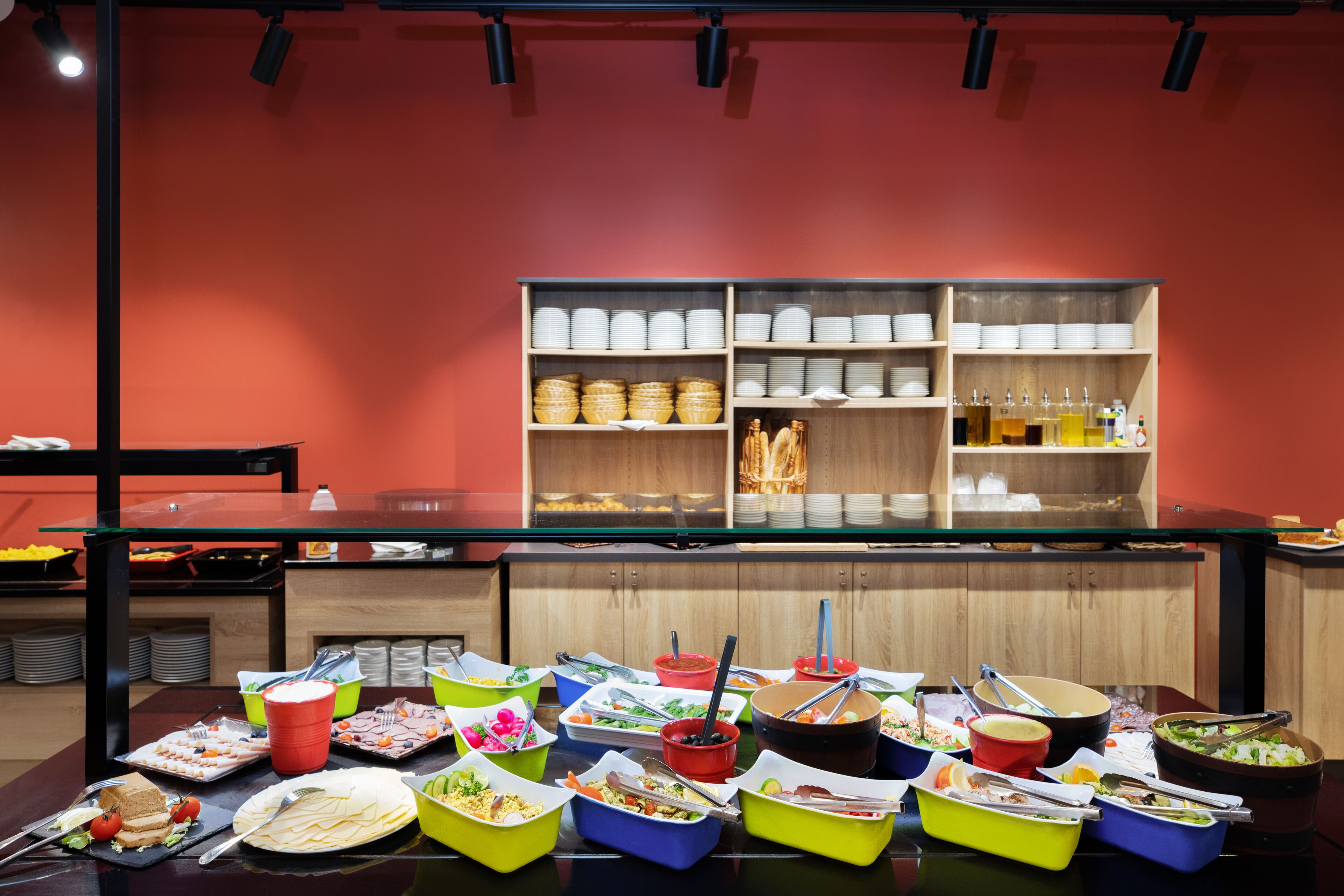 A buffet setup with various food containers and utensils.