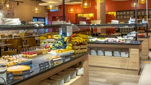 A buffet area with various food items and a seating area with chairs. - SOWELL RÉSIDENCES Les Chênes Verts (Saint-Raphael)