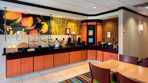 A hotel breakfast area with a buffet, seating, and a large fruit mural. - Fairfield by Marriott Inn & Suites Verona Turning Stone (Verona)