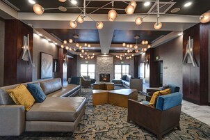 Un hall con sofás, sillones, chimenea e iluminación colgante.
