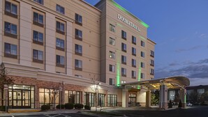 A DoubleTree hotel with a brick facade, large windows, and a covered entrance. - DoubleTree by Hilton Denver International Airport (Denver)
