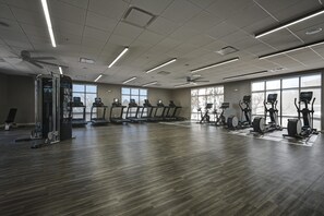 A spacious gym with multiple treadmills, elliptical machines, and a weight machine. - DoubleTree by Hilton Denver International Airport (Denver)