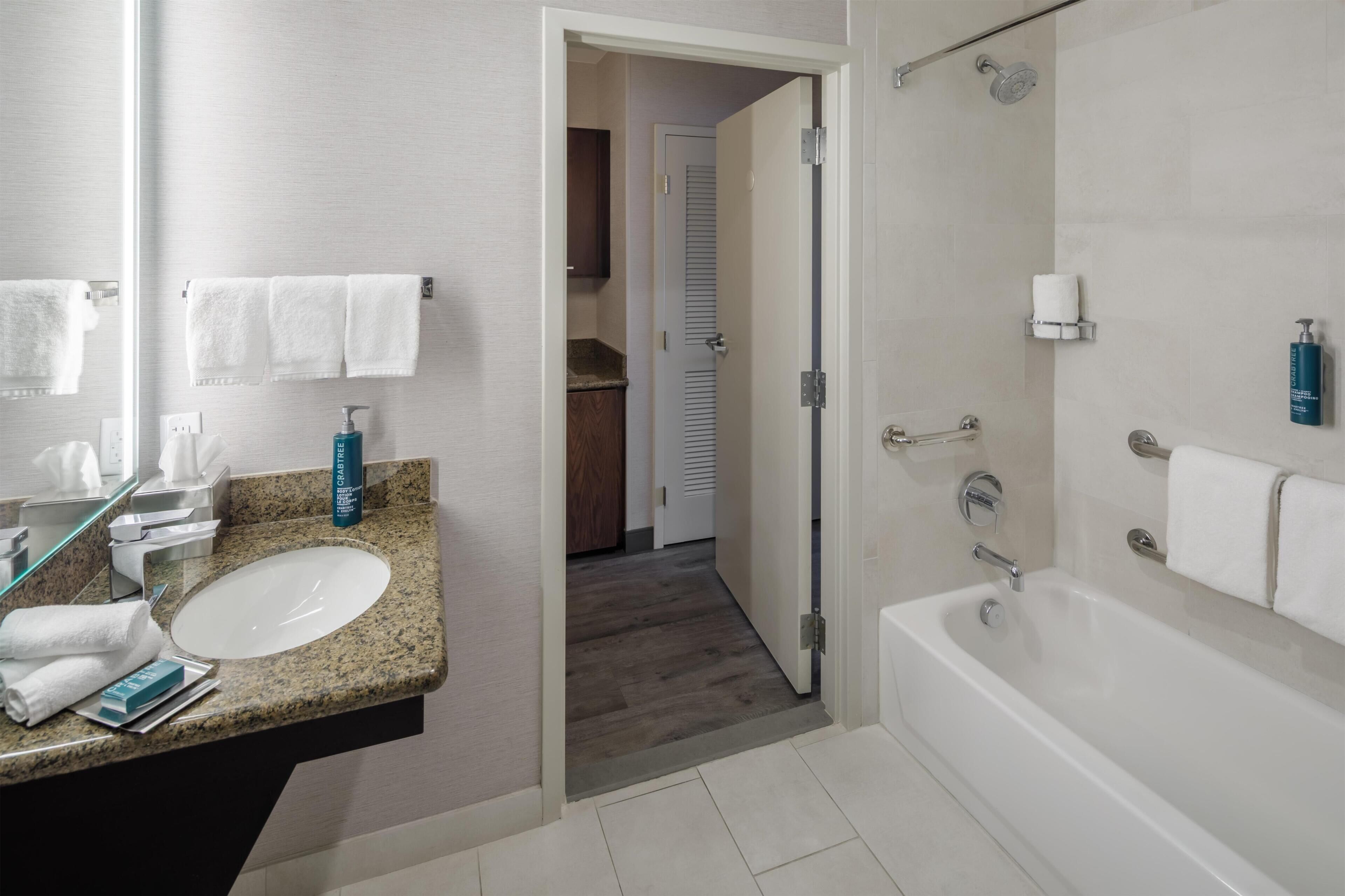 Un baño moderno con lavamanos, espejo y zona de ducha.