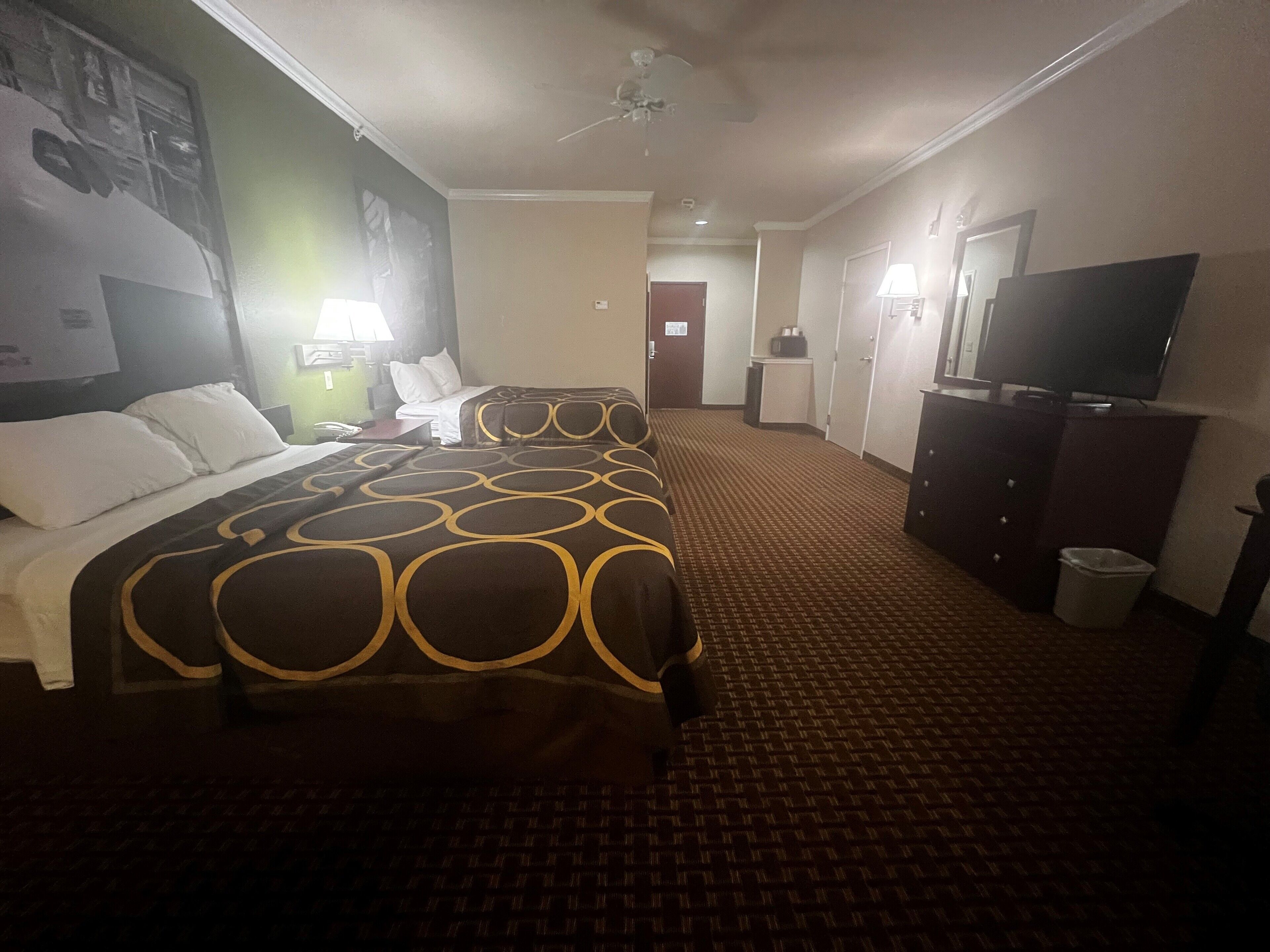 Una habitación de hotel con cama, televisión, escritorio y silla.