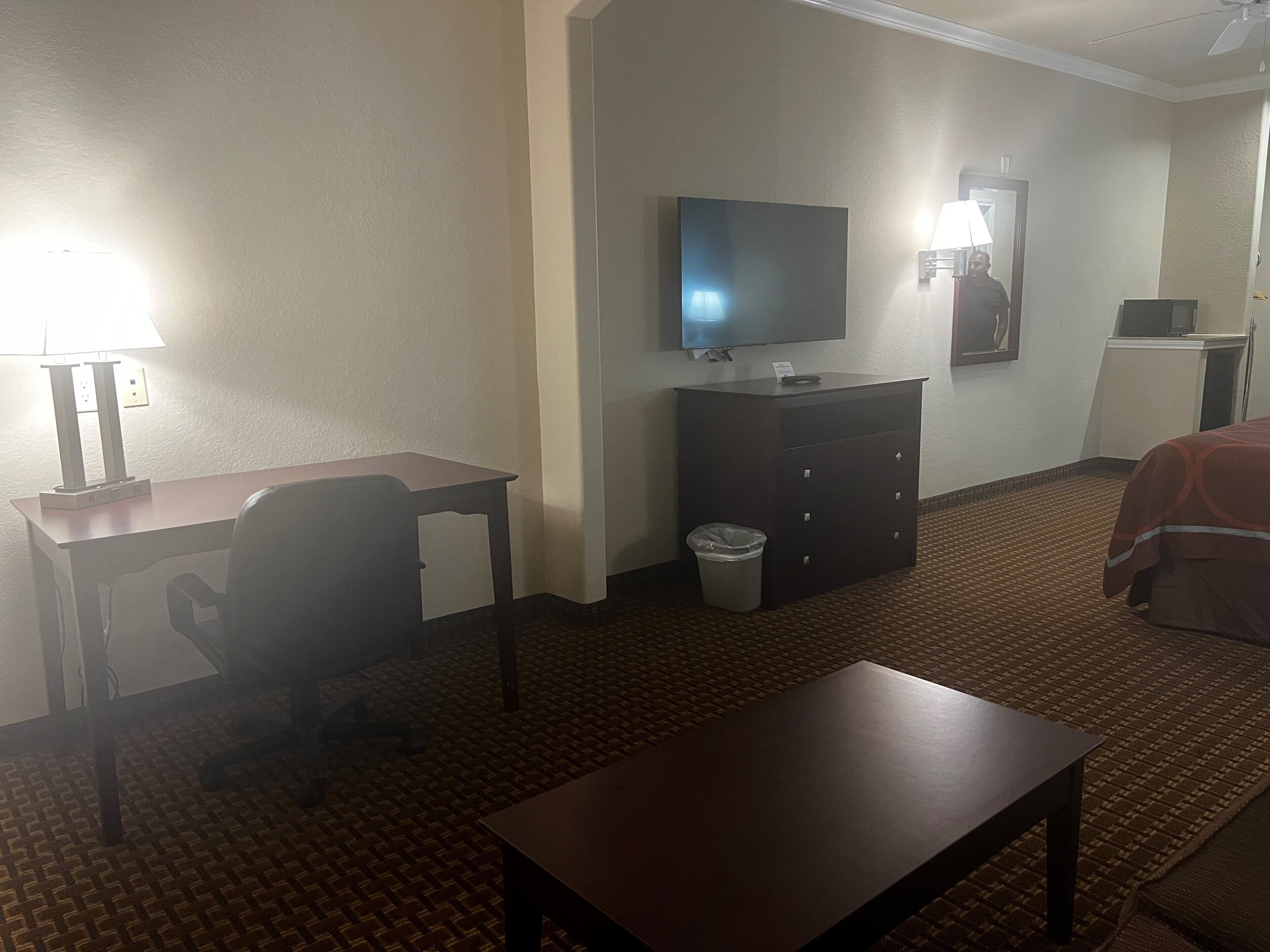 Une chambre d’hôtel équipée d’un bureau, d’une chaise, d’une télévision et d’un lit.