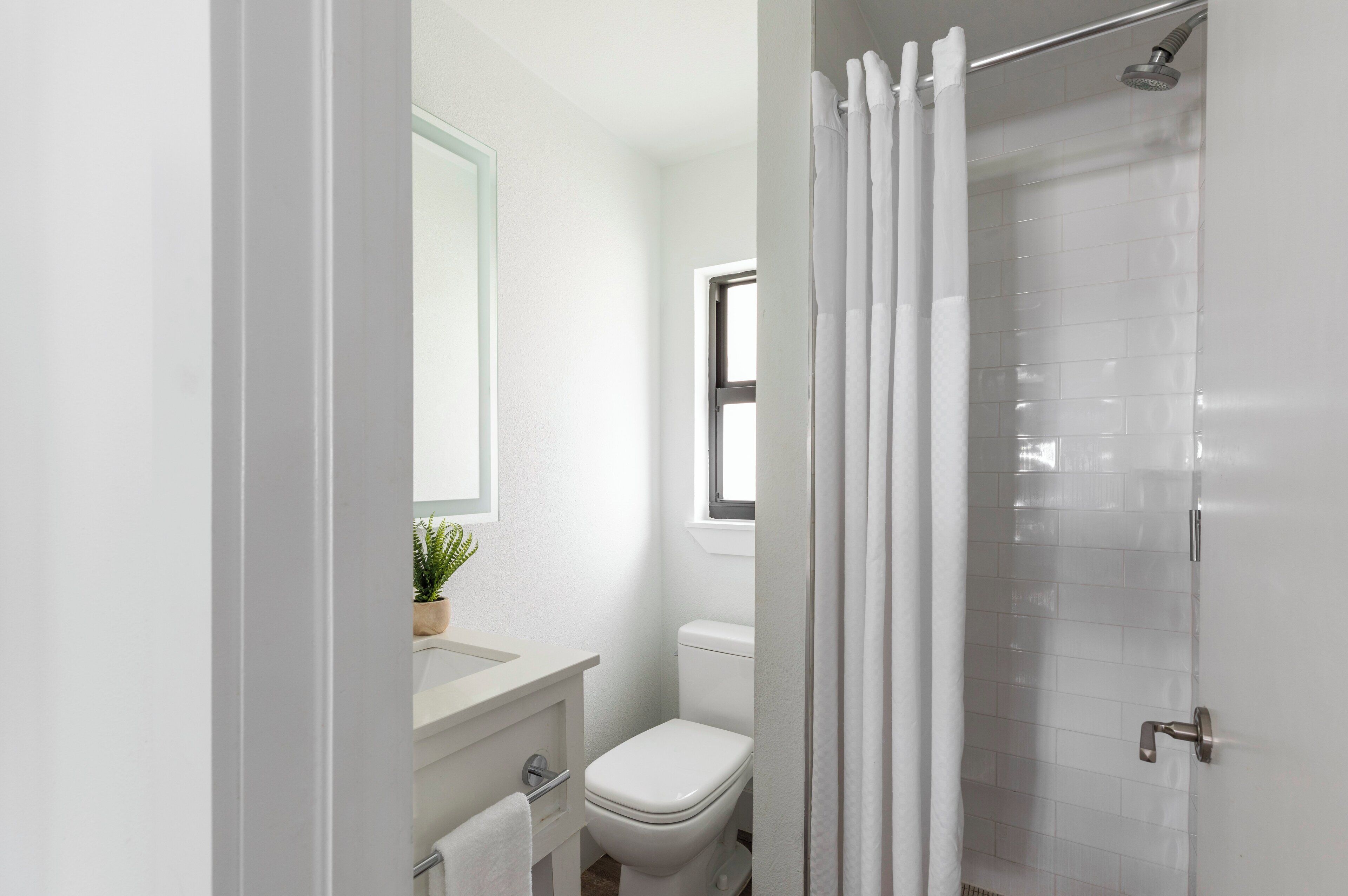 A modern bathroom with a toilet, sink, and shower.