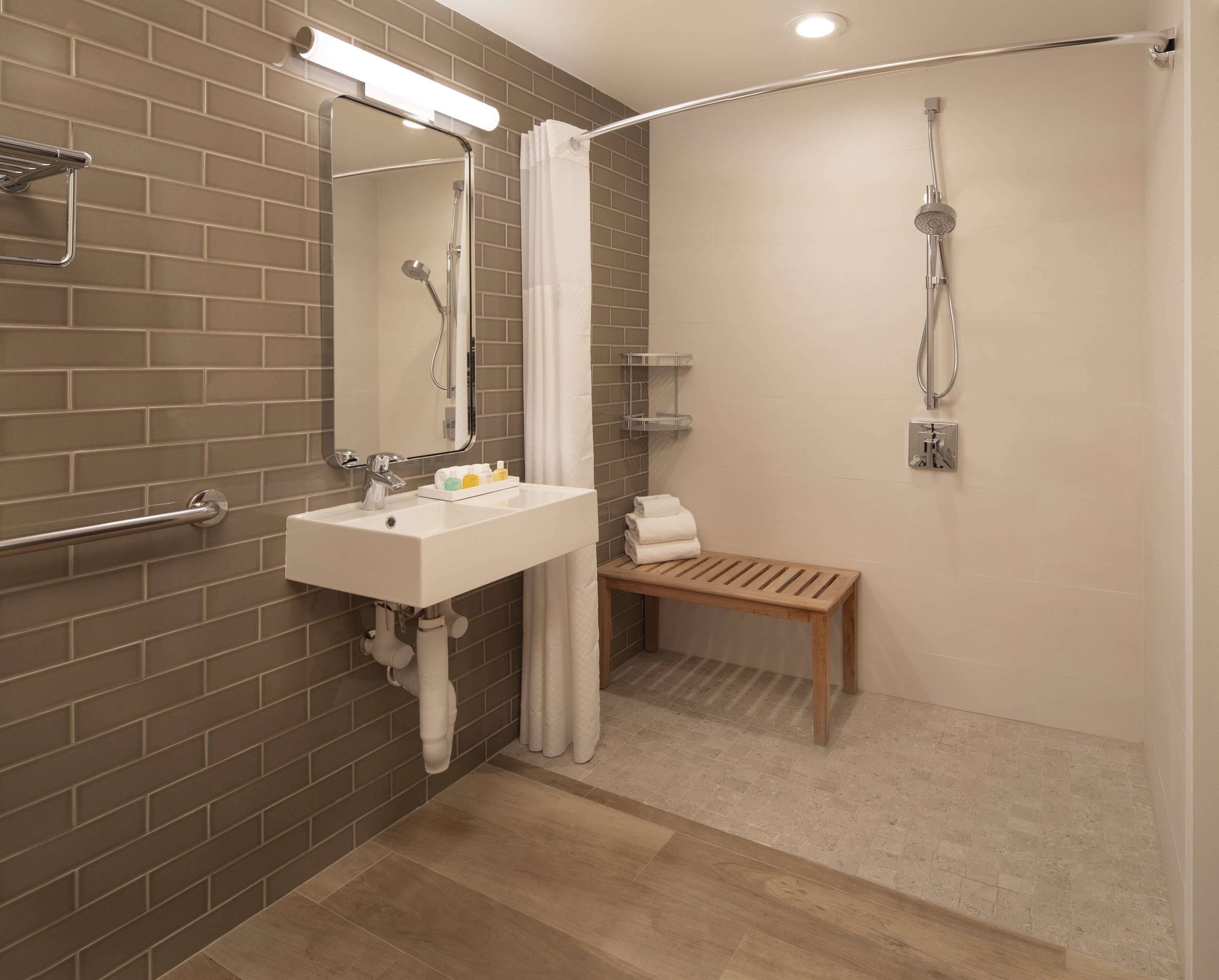 A modern bathroom with a shower, sink, and mirror.